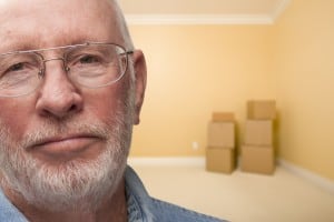 Sad Older Man In Empty Room with Boxes - Concept for Foreclosure, Divorce, Moving, etc.